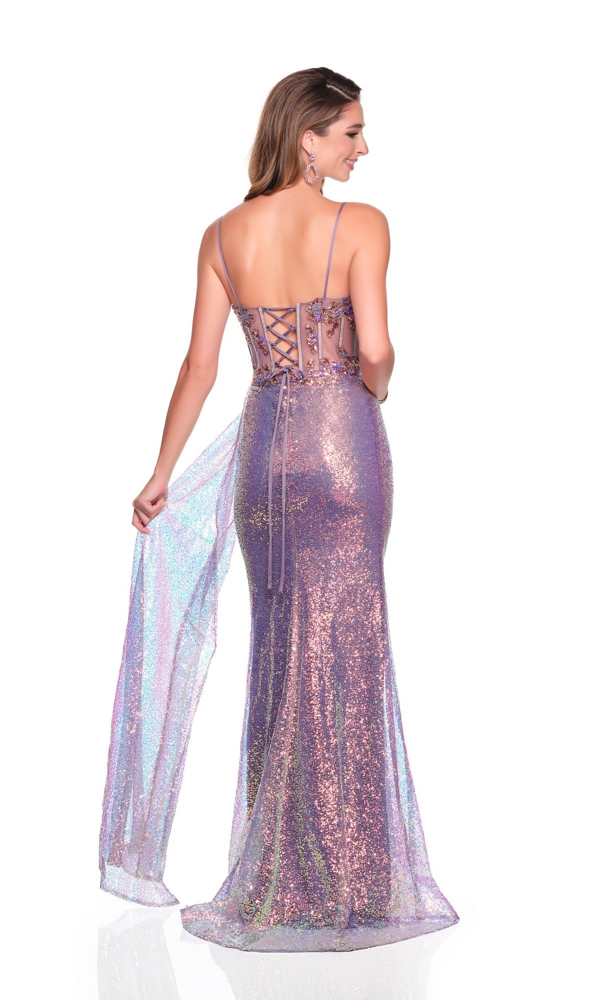 A woman faces away, wearing the Dave and Johnny 12841—a fitted lavender prom dress with sparkly spaghetti straps, lace-up back, sheer shimmering overlay, and a thigh-high slit.